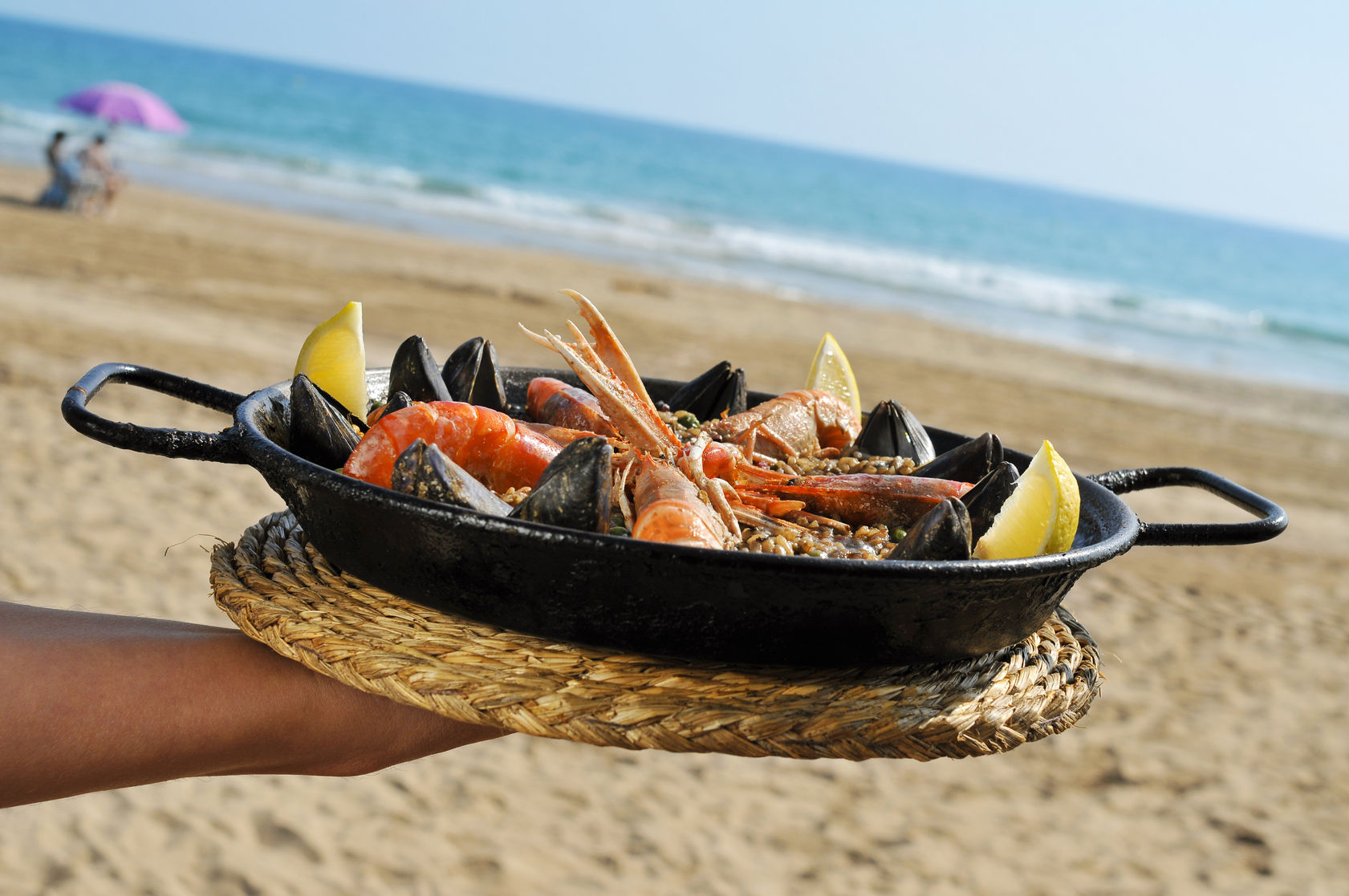 32139727 - a typical spanish paella with seafood in a paellera, the paella pan, on the beach