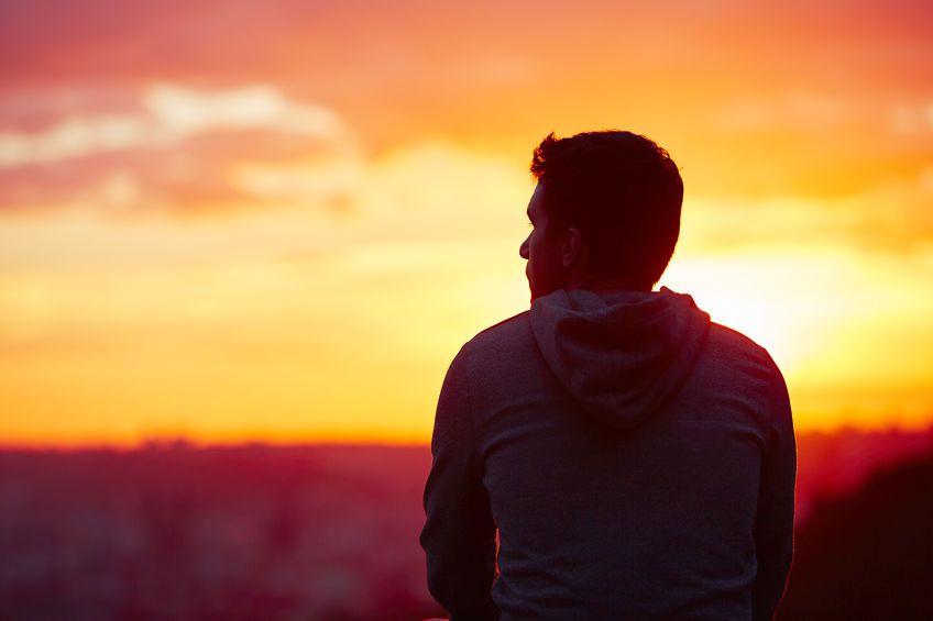 45778974 - young man is looking at the sunrise.